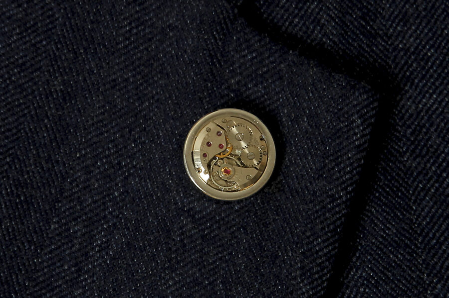 Pin with a watch movement in a massive frame